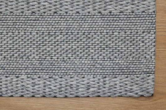 Albi Silver is a Silver and Black, PET Yarn (recycled Plastic) Hand woven flatweave rug. Sizes 160 X 230, 200 X 290 and 240 x 340. Corner.