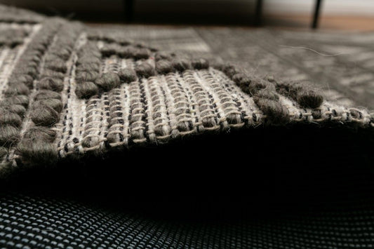 Anita-2 Charcoal is a hand woven textured wool rug. Featuring a tribal geometric design. Colour Charcoal. Sizes 155 X 225, 200 X 290, 240 X 340 and 300 X 400. Side.