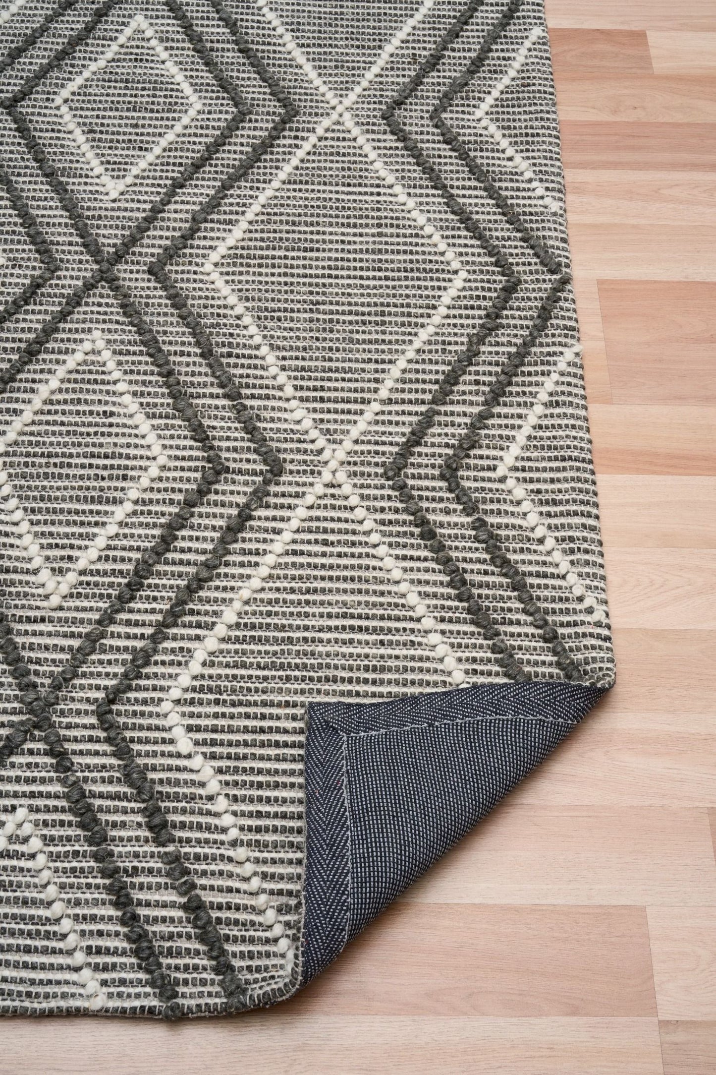 Anita Charcoal is a hand woven textured wool rug. Featuring a tribal geometric design with a 6-8mm pile height. Colour Charcoal, Grey and White. Sizes 155 X 225, 200 X 290, 240 X 320 and 300 X 400. Fold.