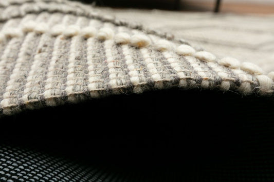 Anita Silver is a hand woven textured wool rug. Featuring a tribal geometric design with a 6-8mm pile height. Colour Silver Grey, Grey and White. Sizes 155 X 225, 200 X 290, 240 X 320 and 300 X 400. Side.