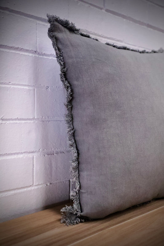 The Antique Grey, cushion is a contemporary cushion with fringes and features a luxurious linen feel. Crafted by skilled artisans in India. Colour grey. Sizes 50 X 50 and 60 X 60. Angle.