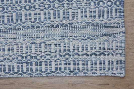Arizona Alloy is a Hand Woven Wool Flatweave. With a Geometric Tribal Design. Colour White with Blue accents. Sizes, 160 X 230, 200 X 290 and 240 X 340. Corner.