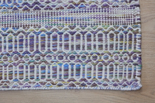 Arizona - Lavender is a Hand Woven Wool Flatweave. With a Geometric Tribal Design. Colour White and Lavender with Multi coloured accents. Sizes, 160 X 230, 200 X 290 and 240 X 340. Corner.
