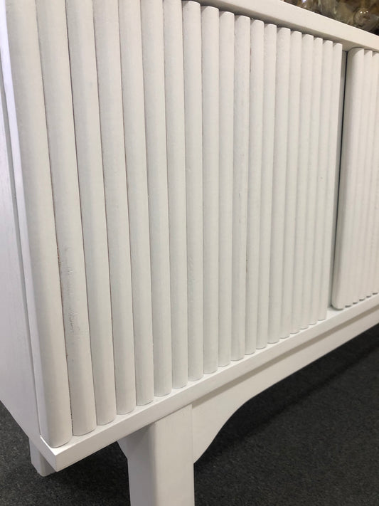 The Astoria 4 Door White buffet is a contemporary styled piece. Crafted from sustainable white cedar, it features 4 textured doors. Colour White. Measures 1800 length X 400 depth X 700 height. Front Angle.