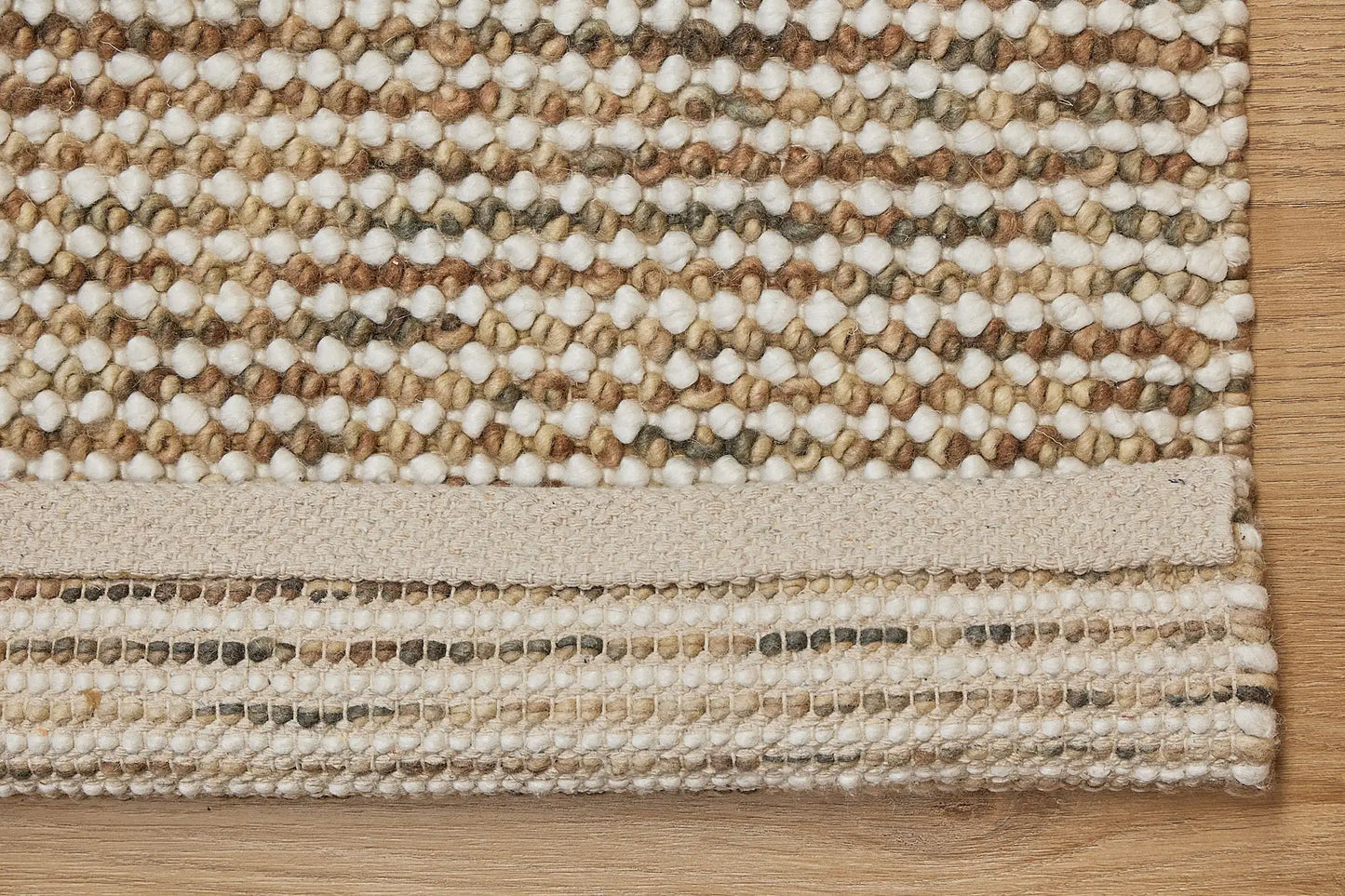 Avila - Beige is a handwoven loop piled carpet. It features a blend of fine wool and viscose, with a pile height of 16-18mm. Colours Beige with Brown accents. Sizes 160 X 230, 200 X 290, 240 X 340 and 300 X 400. Fold.