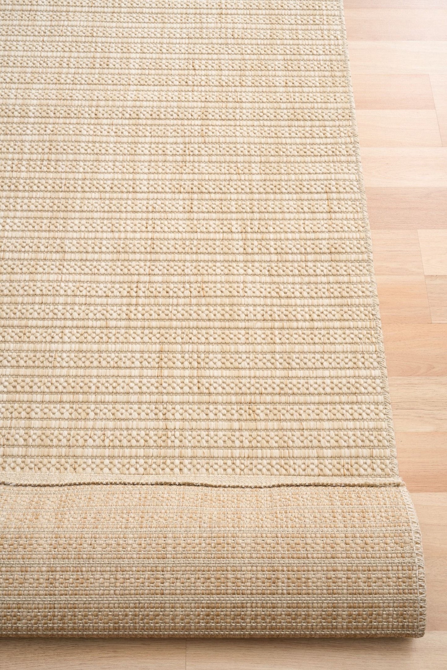 Barton Linear Cream indoor/outdoor rug featuring soft cream tones and a subtle textured pattern, power-loomed from UV-stabilised polypropylene for lasting durability. Colour Cream. 3 sizes. Fold.
