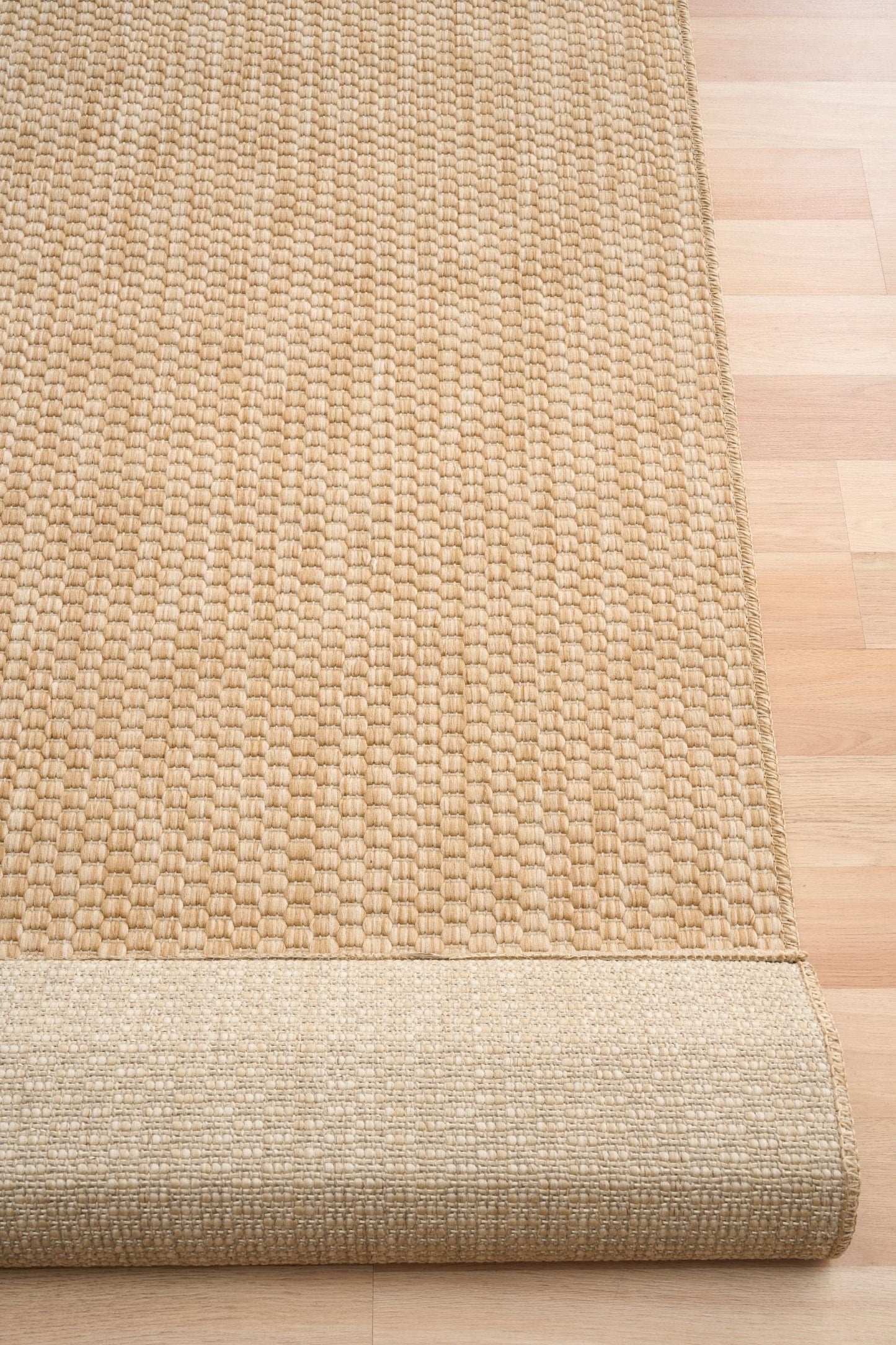 Barton Twill Beige indoor/outdoor rug featuring soft beige tones and a subtle textured pattern, power-loomed from UV-stabilised polypropylene for lasting durability. Colour beige. 3 sizes. Fold.