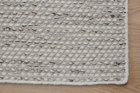 Boa - Salt & Pepper is a hand-woven flatweave, made of wool with a pile height of 7-9mm. Colours White with Black and Grey accents. Sizes 160 X 230, 200 X 290, and 240 X 340. Corner.