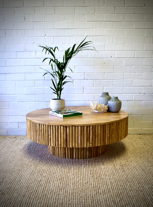 The Buddy Coffee Table is a contemporary/coastal rounded coffee table. Crafted with a solid top, textured sides and base, it is constructed of sustainable fruitwood. Colour natural. Measures 1000 diameter X 380 height. Front styled.