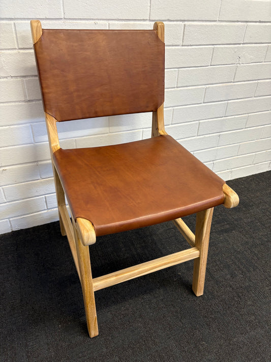 The Cherokee - Brown Dining Chair is crafted from solid teak with a smooth Brown leather seat and back. Colours natural frame with Brown seat and back. Measures 560 Depth x 450 Wide x 500 Seat Height. Back height 820. Angle.