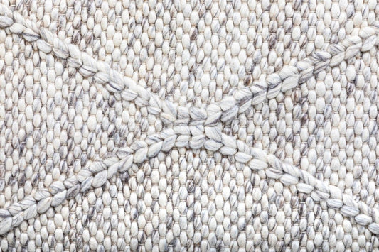 Colombo Light Grey hand-woven flatweave rug in a wool and polyester blend with a braided diamond pattern. Light grey. Close view.