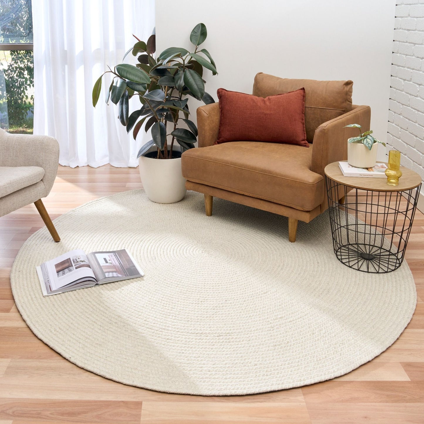 Cora Round Ivory Rug hand woven from 70% New Zealand wool and 30% viscose in a braided weave. Colour Ivory. 2 sizes, 200cm round and 250cm round. Styled View.