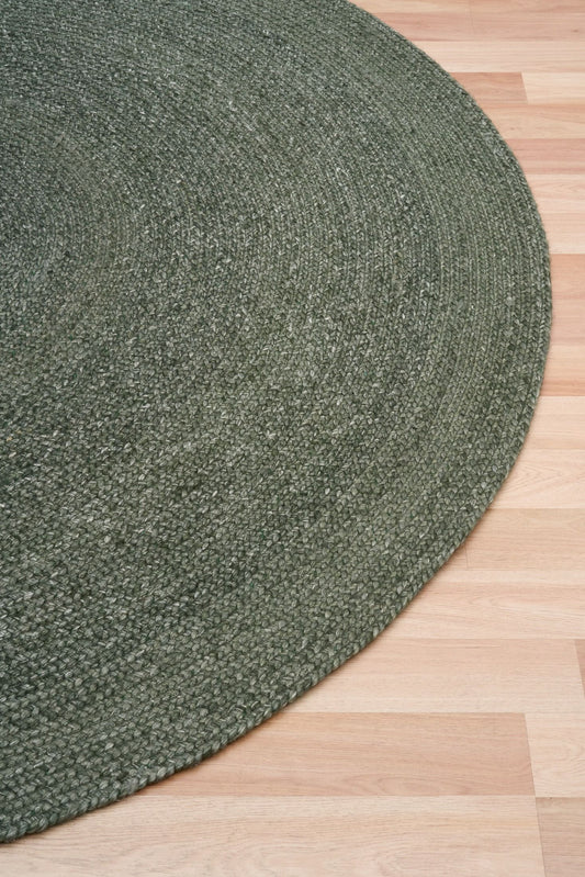 Cora Round Olive Rug hand woven from 70% New Zealand wool and 30% viscose in a braided weave. Colour Dark Olive. 2 sizes, 200cm round and 250cm round. Angle View.