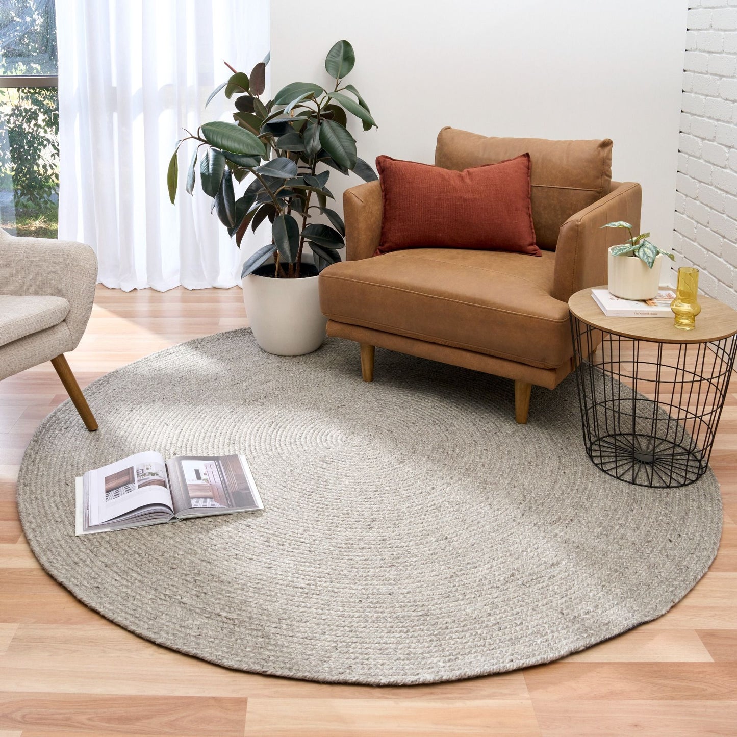 Cora Round Silver Rug hand woven from 70% New Zealand wool and 30% viscose in a braided weave. Colour Silver Grey. 2 sizes, 200cm round and 250cm round. Styled View.