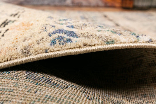 Cozy 5422 Blue Beige is a tribal designed machine made rug. Constructed from luxurious polyester yarn, it features a soft feel. Colours Beige with Cream, Blue and Black patterns. Size 160 X 230. Side.