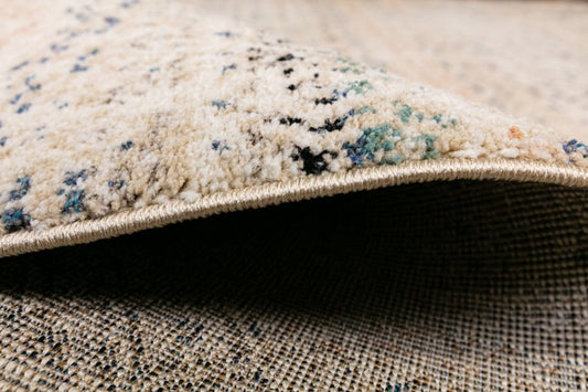 Cozy 5426 Ivory Beige is a tribal patterned designed machine made rug. Constructed from luxurious polyester yarn, it features a soft feel. Colours Beige with Cream, Blue and Black Tribal Patterns. Sizes 160 X 230, 200 X 290. Side.