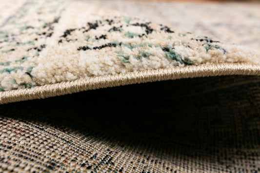 Cozy 5434 Ivory Beige is a tribal patterned designed machine made rug. Constructed from luxurious polyester yarn, it features a soft feel. Colours Ivory Beige with Cream, Black and Blue Tribal Patterns. Size 200 X 290. Side.