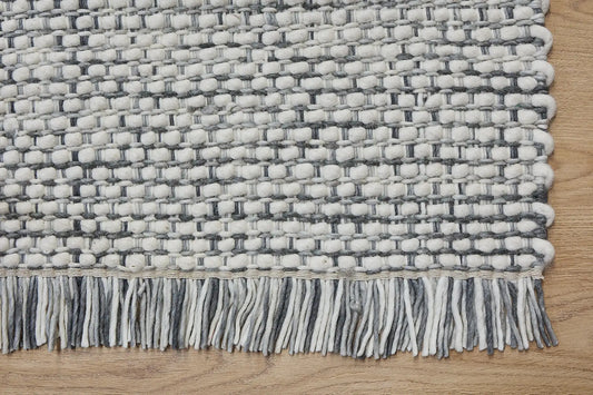 Fancy Grey is a hand braided wool rug with a sumptuous 12-14mm medium pile height. Colours White with greyish accents. Sizes 160 X 230, 200 X 290, 240 X 340. Corner.