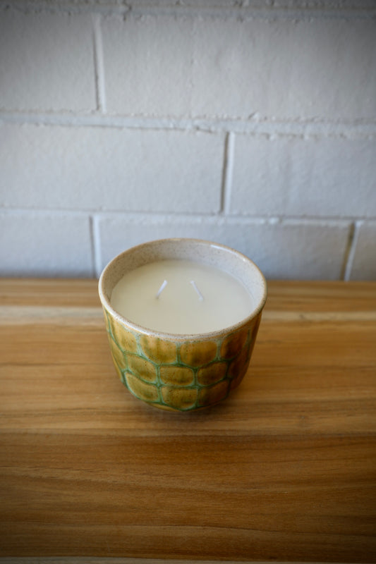 The Finch Ceramic Candle features a patched scaled design. Featuring a lemon grass scent, it's sure to bring a soothing sense to any room. Colours, cream, browns and beiges. Measures 11 Diameter X 9 Height. Top Styled.