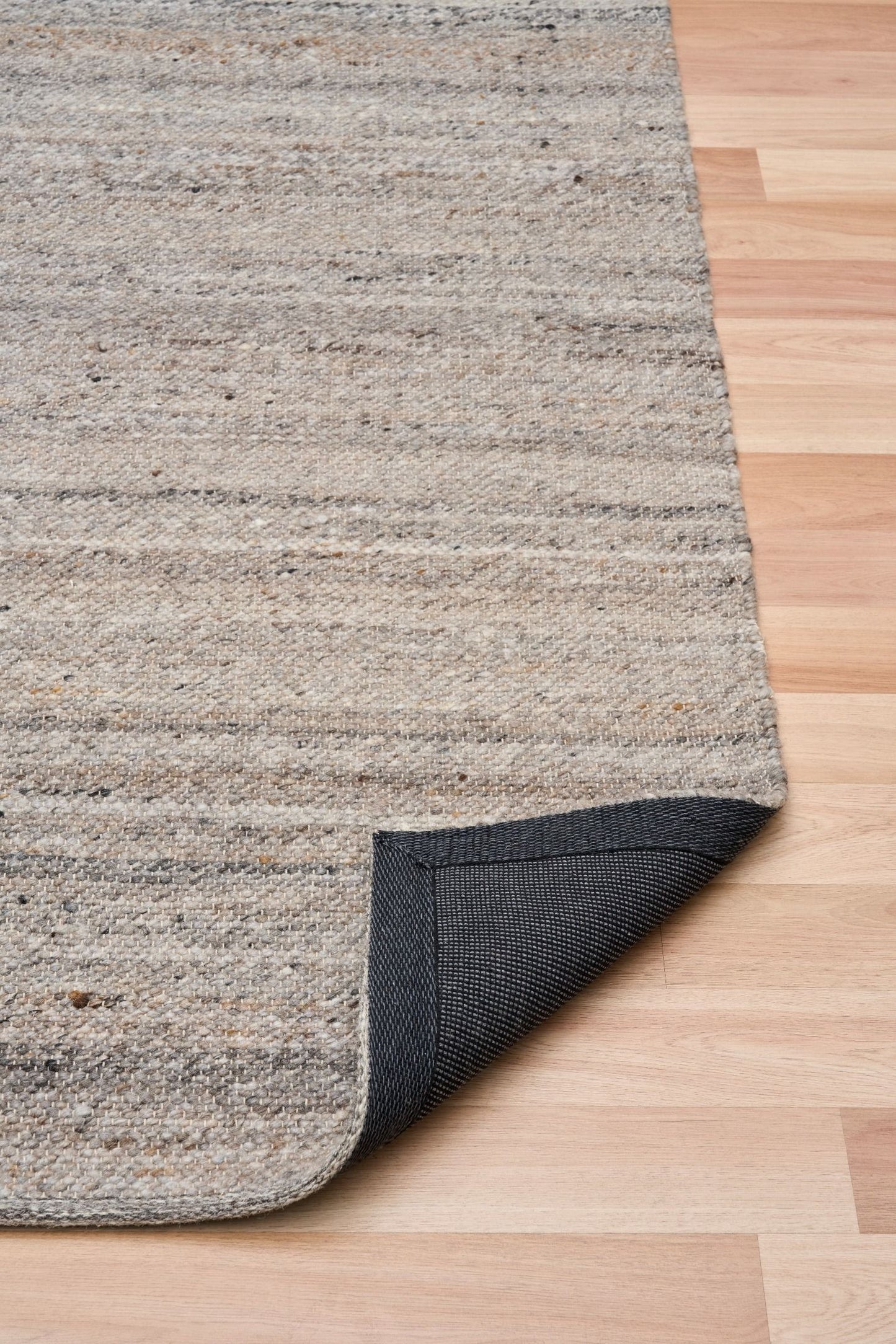 Harmony Dark Grey Rug – hand-woven blend of wool and viscose in soft natural tones, featuring a textured finish that’s both elegant and durable. Colour White, Grey, black and brown flecks. 3 sizes. Fold.