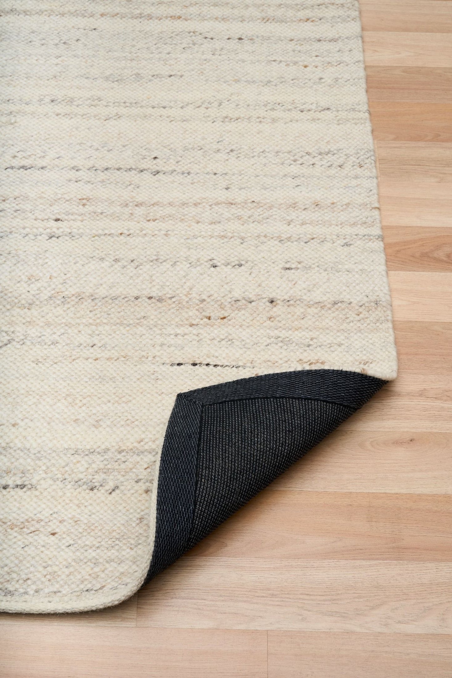 Harmony White Rug – hand-woven blend of wool and viscose in soft natural tones, featuring a textured finish that’s both elegant and durable. Colour White with black and brown fleck. 4 sizes. Fold.