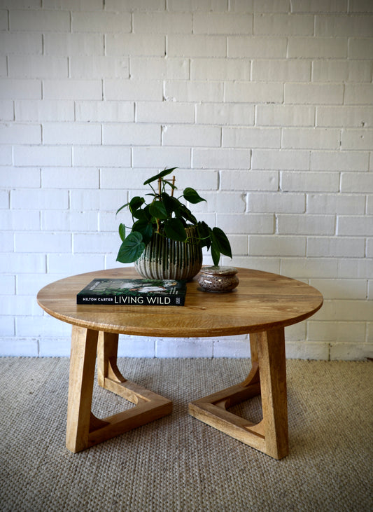 The Hendrix - Round Coffee Table features a round top with unique angled legs. Constructed from sustainable fruitwood. Colour Natural. Measures 850 Diameter X 400 height. Front Styled.