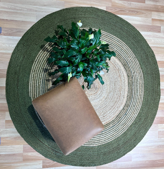 The Juno Echo Green Round Rug. Hand Woven Braided Jute Rug. Colours natural grey base with green. 2 sizes, 120 centimetres and 200 centimetres round. Styled.