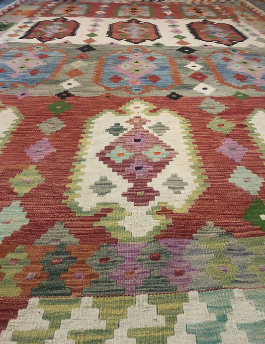 The Afghan Hand Woven Khyber Kilim - 208 X 300. Crafted using traditional vegetable dyed wool, and featuring traditional geometric designs. Colours, blacks, blues, creams, reds, oranges and yellows. Size 208 X 300. Angle.