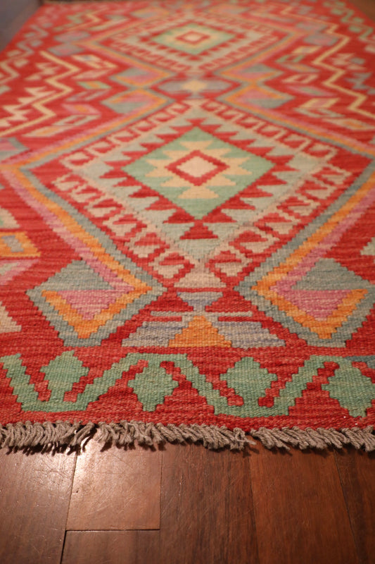 The Afghan Hand Woven Khyber Kilim - 124 X 176. Crafted using traditional vegetable dyed wool, and featuring traditional geometric designs. Colours, Oranges, beiges, creams, lavender. Size 124 X 176. Angle.