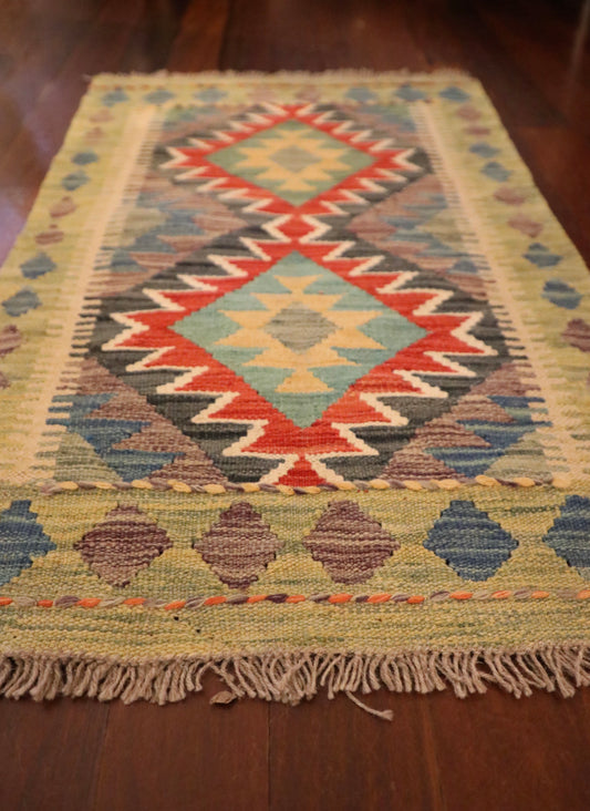 The Afghan Hand Woven Khyber Kilim - 59 X 90. Crafted using traditional vegetable dyed wool, and featuring traditional geometric designs. Colours, beiges, blues, creams, light greens, light blues and yellows. Size 59 X 90. Angle.