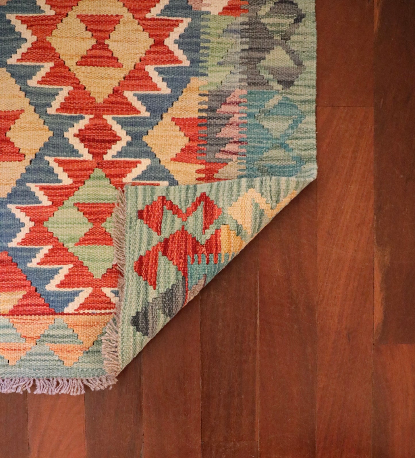 The Afghan Hand Woven Khyber Kilim - 60 X 85. Crafted using traditional vegetable dyed wool, and featuring traditional geometric designs. Colours, Dark oranges, creams, light greens, light blues yellows. Size 60 X 85. Fold.