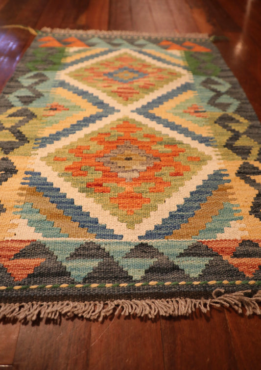 The Afghan Hand Woven Khyber Kilim - 60 X 87. Crafted using traditional vegetable dyed wool, and featuring traditional geometric designs. Colours, dark greys, beiges, blues, creams, light greens, light blues and yellows. Size 60 X 87. Angle.