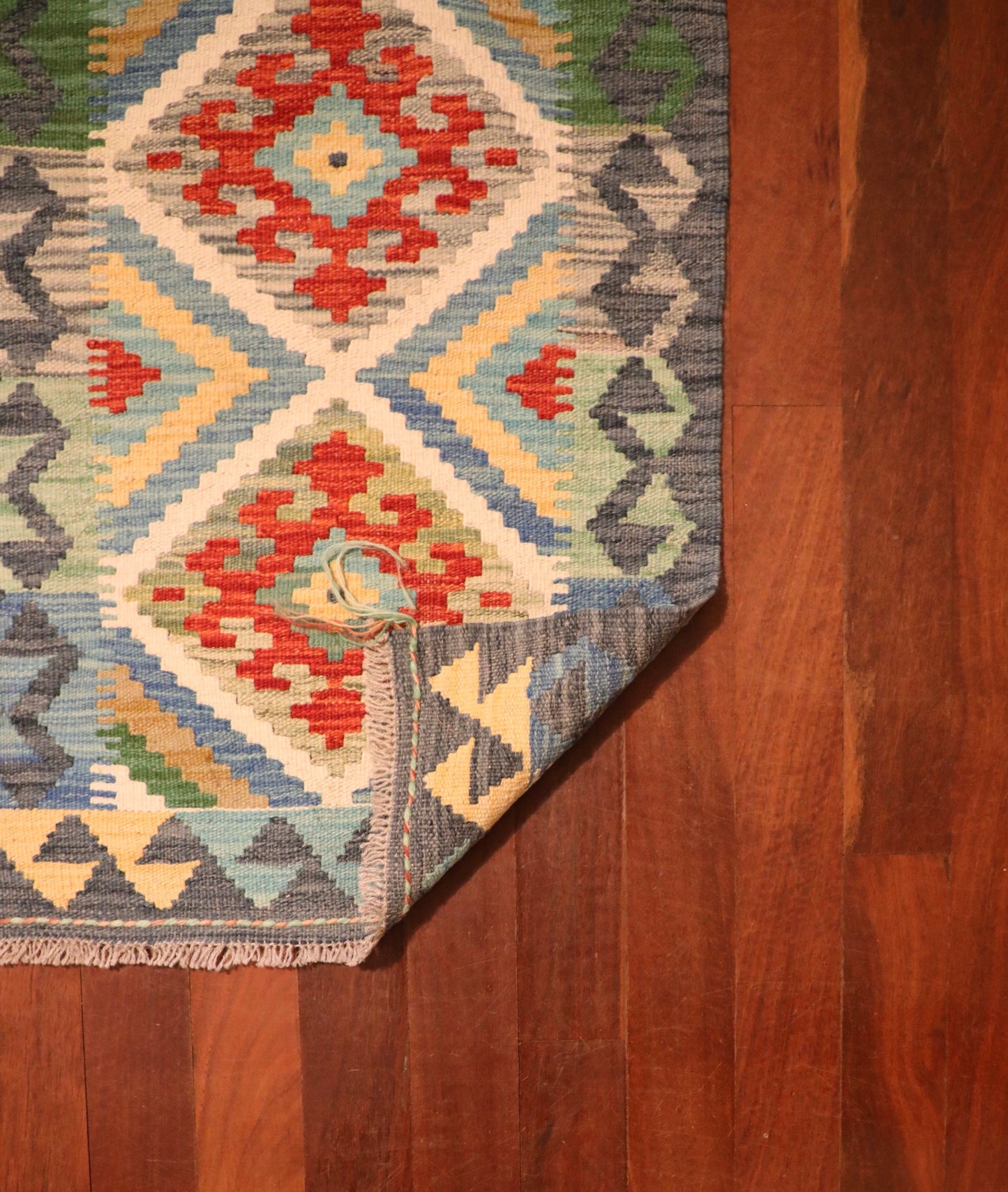 The Afghan Hand Woven Khyber Kilim - 60 X 88. Crafted using traditional vegetable dyed wool, and featuring traditional geometric designs. Colours, greys, creams, light blues, reds and orange. Size 60 wide X 88 length. Fold.