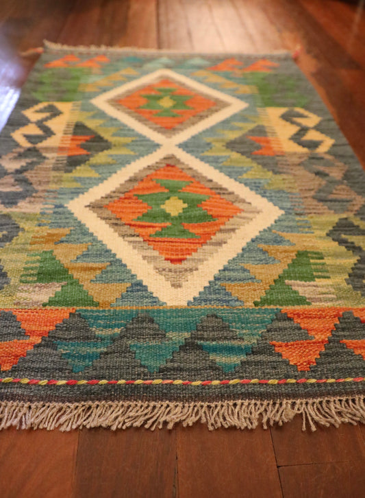 The Afghan Hand Woven Khyber Kilim - 61 X 86. Crafted using traditional vegetable dyed wool, and featuring traditional geometric designs. Colours, dark greys, beiges, blues, creams, light greens, light blues and yellows. Size 61 X 86. Angle.