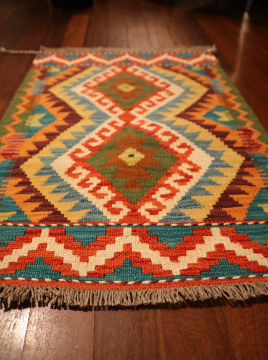The Afghan Hand Woven Khyber Kilim - 62 X 87. Crafted using traditional vegetable dyed wool, and featuring traditional geometric designs. Colours, reds, beiges, creams, oranges, light greens, light blues and yellows. Size 62 X 87. Angle.