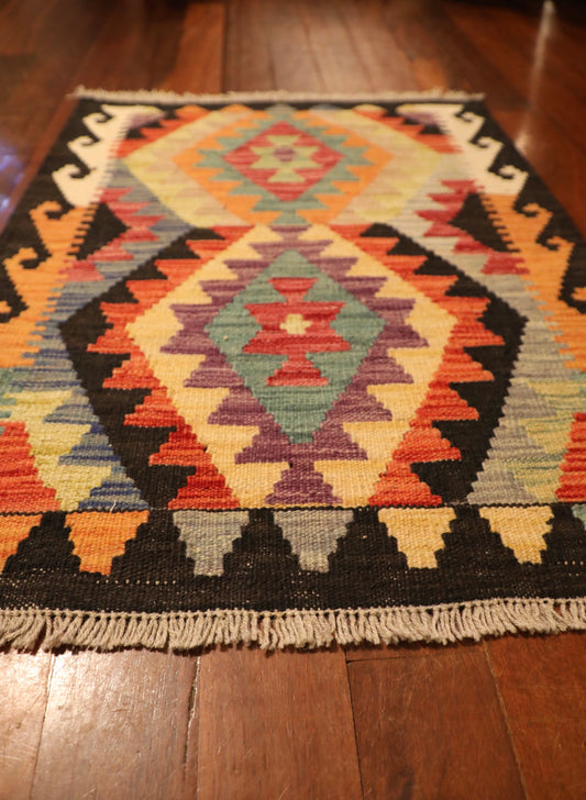 The Afghan Hand Woven Khyber Kilim - 65 X 87. Crafted using traditional vegetable dyed wool, and featuring traditional geometric designs. Colours, navy blue, reds, beiges, creams, oranges, light greens, light blues and yellows. Size 65 X 87. Angle.