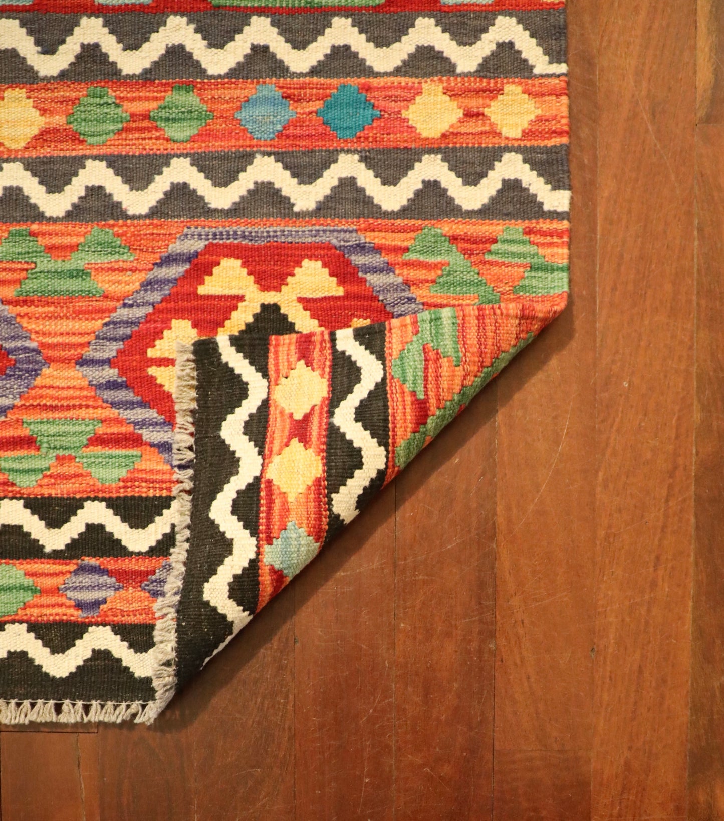 The Afghan Hand Woven Khyber Kilim Runner - 84 X 300. Crafted using traditional vegetable dyed wool, and featuring traditional geometric designs. Colours, reds, yellows, creams, beiges, oranges, light greens and more. Measures 84 wide X 300 long. Fold.