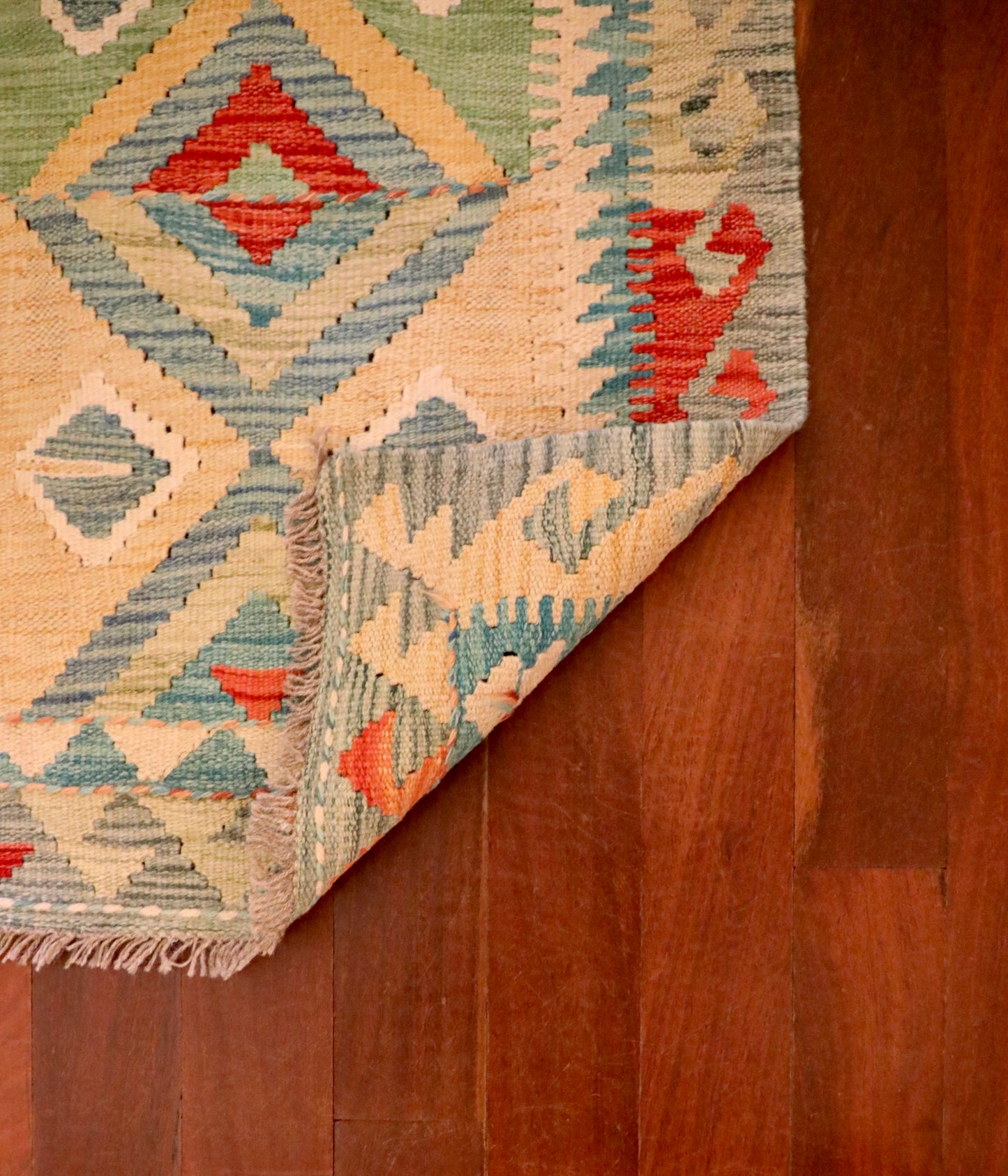 The Afghan Hand Woven Khyber Kilim - 60 X 84. Crafted using traditional vegetable dyed wool, and featuring traditional geometric designs. Colours, Dark oranges, creams, light greens, light blues yellows. Size 60 X 84. Fold.