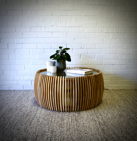 The Lennon Coffee Table is a contemporary round coffee table crafted with a sleek glass top and a slated teak base. Colour natural. Measures 900 diameter X 400 height. Front Styled.