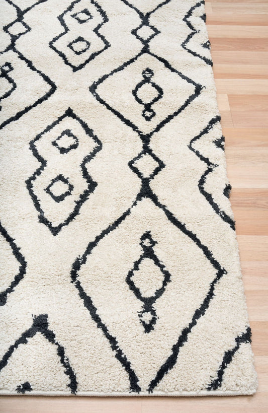 Luana Column Ivory Charcoal is a machine made polypropylene rug. It features a shaggy pile with a moroccan boho inspired design. Colours Ivory with a charcoal moroccan inspired diamond pattern. Sizes 160 X 230, 200 X 290, 240 X 320 and 300 X 390. Corner.
