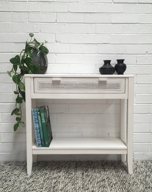 The Milan - 1 Drawer White console boasts coastal and contemporary style. Crafted from sustainable white cedar timber, it features 1 drawer, on wooden runners, and an open mesh rattan drawer face. Colour White. Measures 800 length X 250 depth X 750 height. Front Styled.