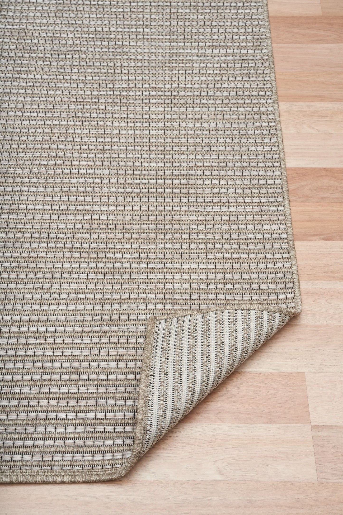The Patio Basket Straw indoor/outdoor rug featuring neutral tones and a modern designed pattern, power-loomed from UV-stabilised polypropylene for lasting durability. Colours Greys, Beiges and hints of light grey. 3 sizes. Fold.