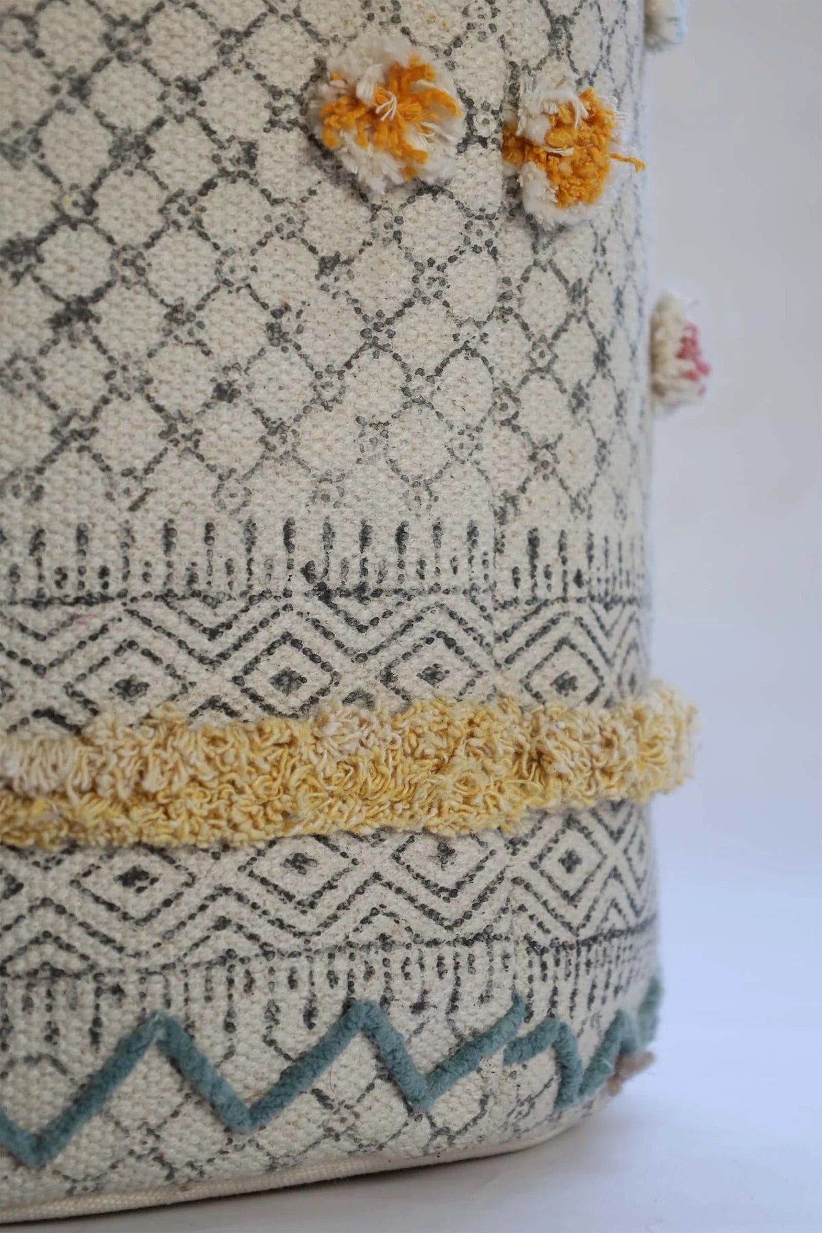 The Pearled Cotton Block Print Basket, boasts a bold motif block print design and 2 handles. Featuring an interior cotton lining and an outer textured cotton cover. Colours, creams, dark blues, yellows and browns. Size 400 height X 350 diameter. Bottom Corner.