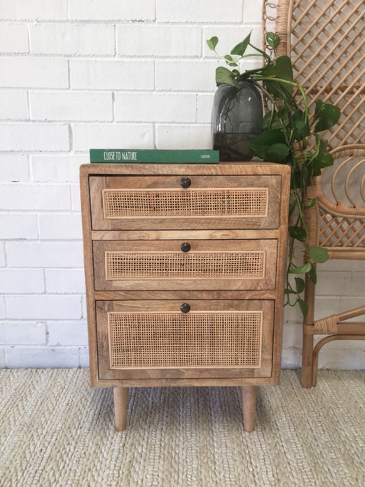 The Rainier 3 drawer bedside is constructed from fruitwood and features rattan mesh drawer faces. Each of the three drawers are on wood runners. Colour natural. Measures 450 length X 330 depth X 660 height. Front Styled.