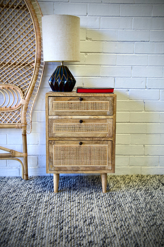 The Rainier 3 drawer bedside is constructed from fruitwood and features rattan mesh drawer faces. Each of the three drawers are on wood runners. Colour natural. Measures 450 length X 330 depth X 660 height. Front Styled.