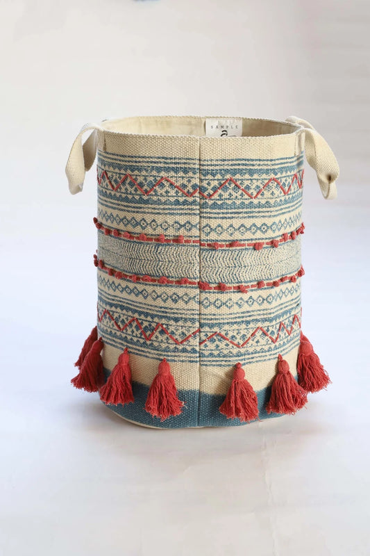 The Redwood Cotton Block Print Basket, showcases a bold motif block print design and 2 handles. Featuring an interior cotton lining and an outer cotton textured cover with red tassels. Colours, cream, blue, and red. Size 400 height X 350 diameter. Side Plain.