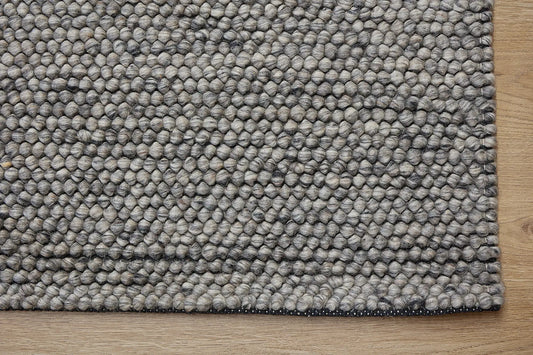 Rocks Grey is a luxurious hand-woven wool carpet. Boasting a plush loop pile with 8-18mm pile height. Colour Grey with Dark grey accents. Sizes 160 X 230, 200 X 290, 240 X 340 and 290 X 390. Corner.