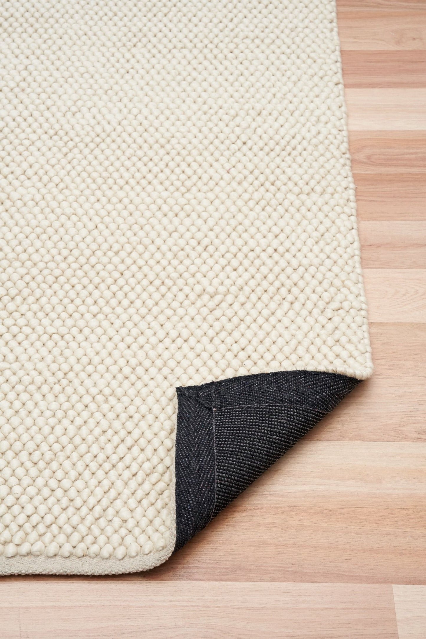 Rusta Cream hand-woven wool rug featuring a looped pile textured design in soft neutral cream tones, ideal for modern and contemporary interiors. Sizes 155 X 225, 200 X 290, 240 X 320 and 300 X 400. Fold.