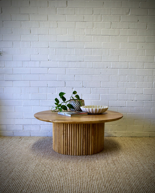 The Santana - Natural Coffee Table Natural is a contemporary centrepiece. It features a round table top and textured column base. Colour natural. Measures 1000 diameter X 400 height. Front Styled.