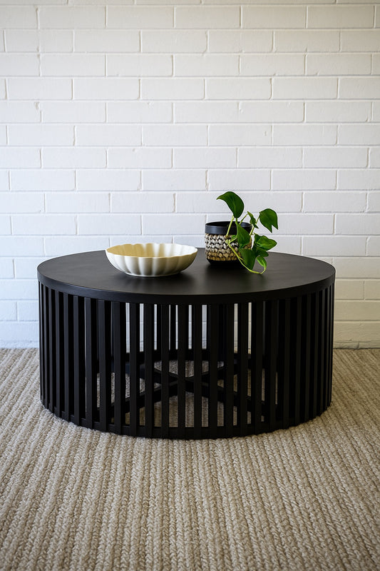 The Seger Black Coffee Table features solid round top and slatted sides. Crafted from sustainable fruitwood. Colour Black. Measures 900 diameter X 400 height. Styled.